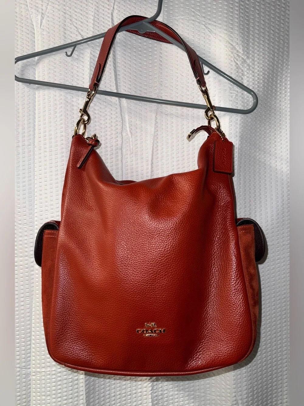 Coach Pennie Shoulder Bag features gold hardware and side suede pockets